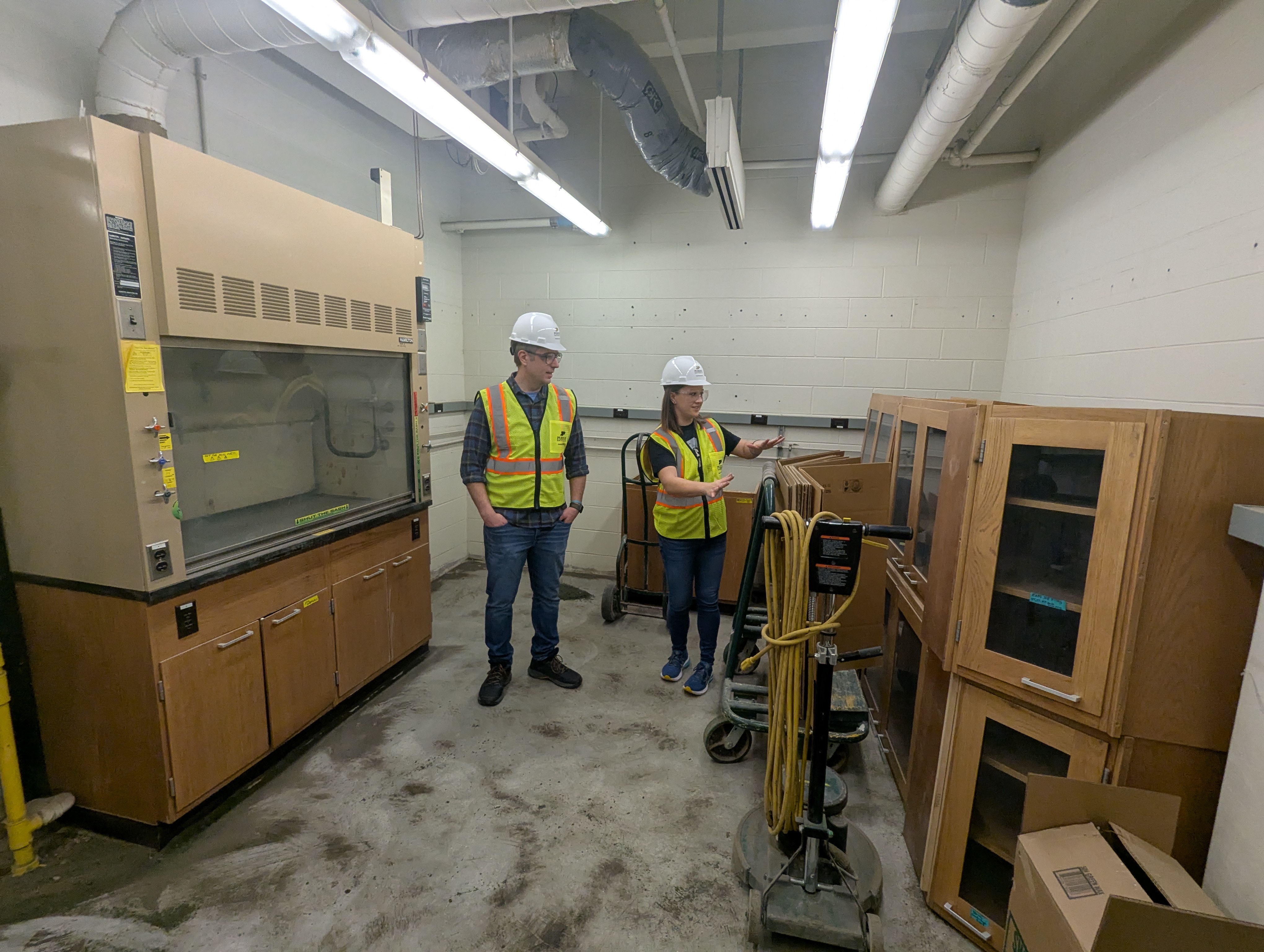 two scientists dressed in construction PPE inspect demo